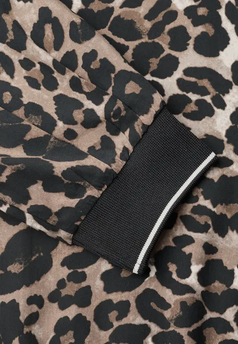 Ärmelsaum mit Leopardenmuster und breitem schwarzen Bündchen mit weißem Streifen.