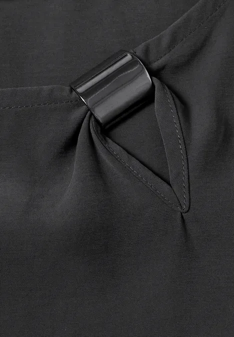 Blouse met ronde hals en gespdetail armor grey Close-up van zwarte stof met zak en zwarte metalen ring.