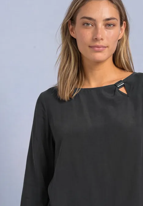 Blouse met ronde hals en gespdetail armor grey Een vrouw met lang lichtbruin haar en een zwarte blouse met lange mouwen tegen een neutrale achtergrond.
