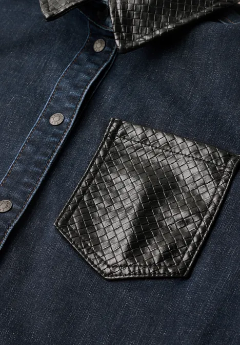 Dunkelblaue Jeansjacke mit glänzender, strukturierter schwarzer Lederbrusttasche.