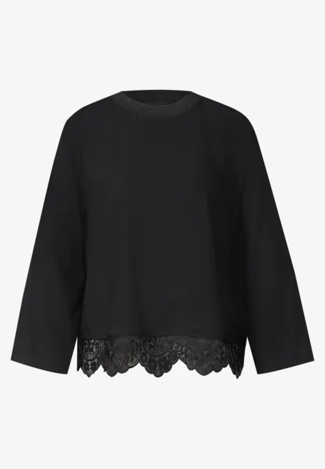 Schwarze Bluse mit Rundhalsausschnitt, weiten Ärmeln und Spitzenbesatz am Saum.