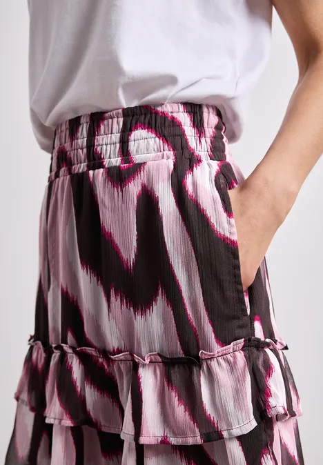 Mehrstufiger Rüschenrock mit abstraktem Schwarz-Weiß-Pink-Muster und elastischem Bund.