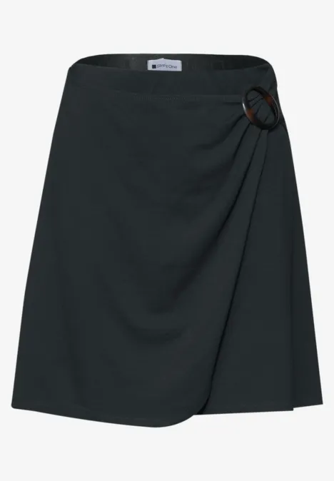 schwarzer, knielanger Wickelrock mit dekorativem Ringdetail an der Taille.