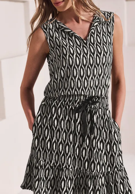 Jupe au genou à imprimé et à volants clay sand Robe d’été sans manches à motif ethnique noir et blanc, encolure en V, ceinture taille et poches.
