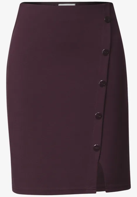 Jupe crayon violet foncé taille haute, fermeture à boutons sur le côté et fente discrète.