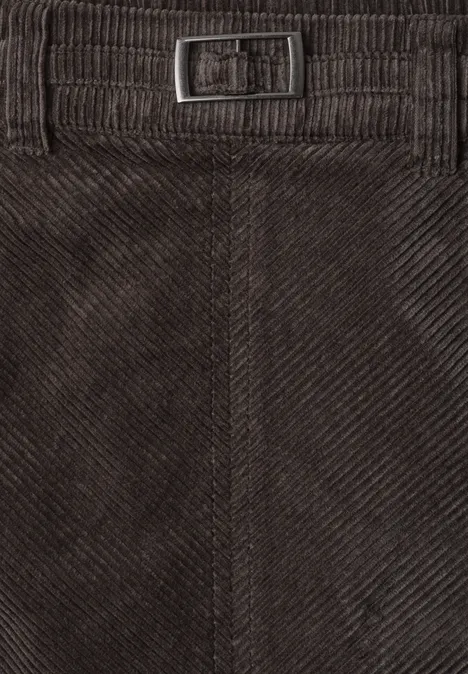 Close-up van een donkerbruine ribfluwelen broekband met verstelbare metalen gesp.