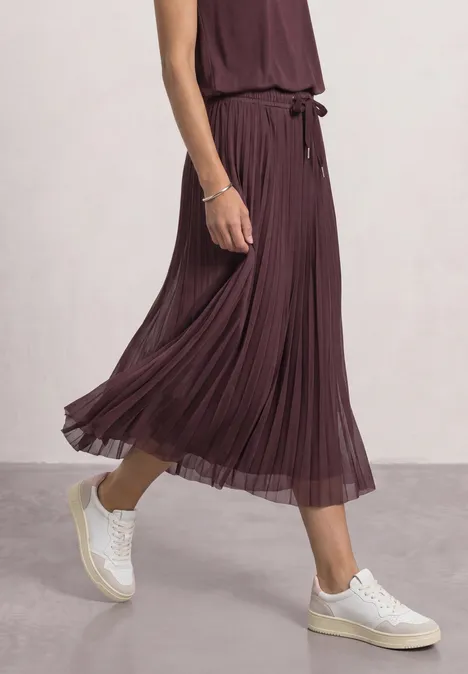 Midirok van mesh met plissé-structuur rustic rouge Eine Person trägt einen plissierten, burgundfarbenen Midirock und weiße Sneaker vor neutralem Hintergrund.