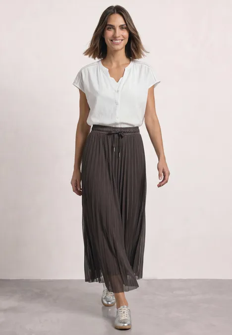 Midirok van mesh met plissé-structuur black coffee Frau in weißer Bluse mit kurzen Ärmeln und braunem, plissiertem Midirock mit Gürtel.