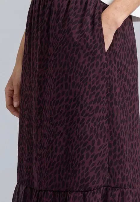 Lila Midirock mit schwarzem Leoprint, seitlicher Tasche und Rüschensaum.
