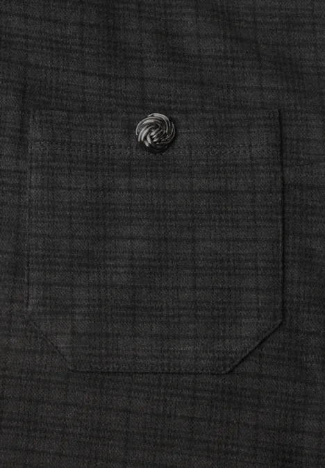 Gros plan d’une poche en tissu gris foncé avec un petit bouton rond argenté.
