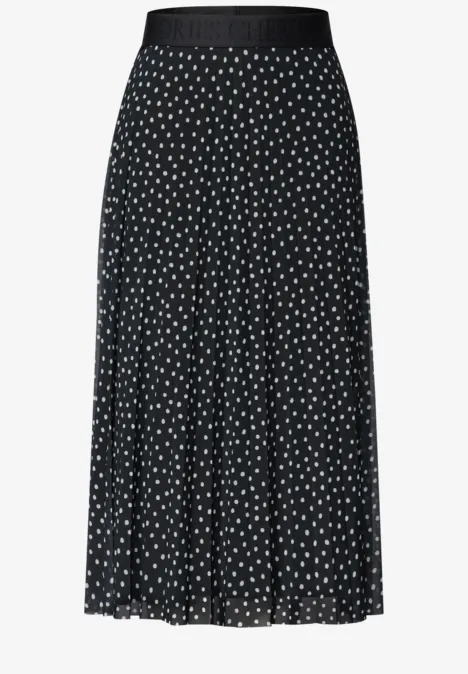 Jupe midi noire plissée à pois blancs, taille élastique.