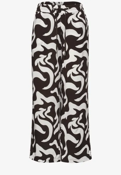 Wijde palazzo-broek van licht stof met abstract zwart-wit patroon.