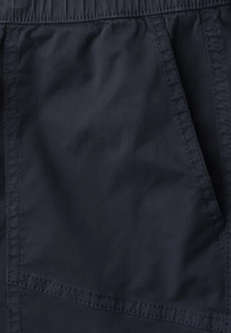 Close-up van een donkerblauwe broek met schuine steekzak