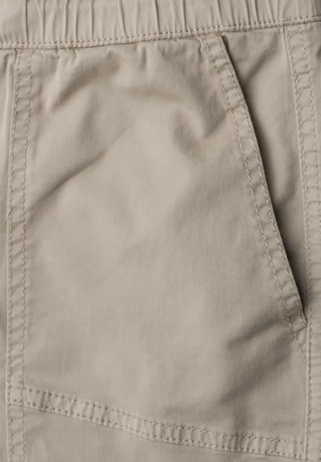 Slim Leg broek in papertouch kwaliteit buff grey Close-up van een beige broekzak met elastische tailleband en zichtbare stiksels.