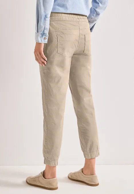 Slim Leg Hose in Papertouch-Qualität cobble stone Person von hinten trägt hellbeige Chino-Hose mit elastischem Bund an den Knöcheln und hellblaues Hemd.