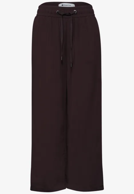 Dunkelbraune, weit geschnittene Hose mit elastischem Bund und Tunnelzug, lässig und lang geschnitten.