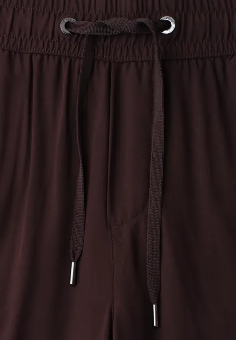 Braune Hose mit elastischem Bund und Kordelzug, Nahaufnahme des Taillenbereichs.