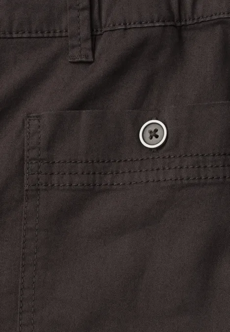 Close-up van een donkerbruine stoffen zak met klep en ronde knoop.