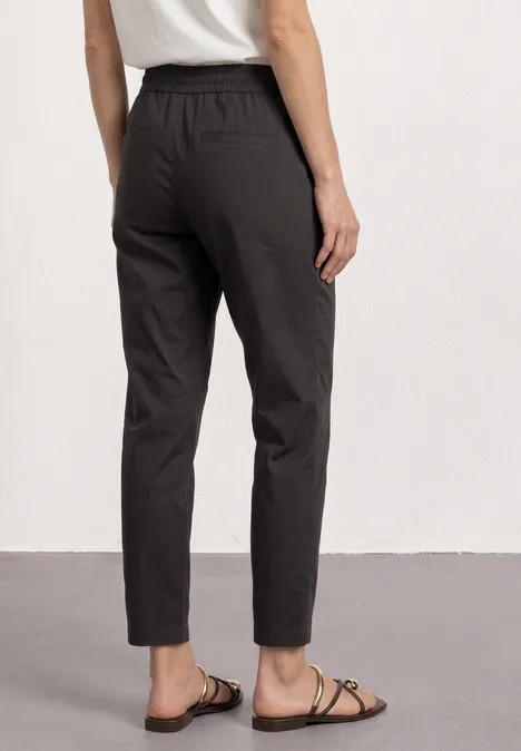Hoch taillierte, dunkelgraue Damenhose mit Gummibund und schmal zulaufenden Beinen.