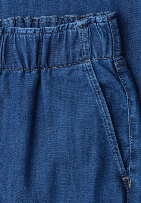 Nahaufnahme einer blauen Jeans mit elastischem Bund und seitlicher Tasche.