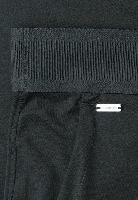 Zwarte sportlegging met brede tailleband, zijzak en klein wit label aan de zoom.