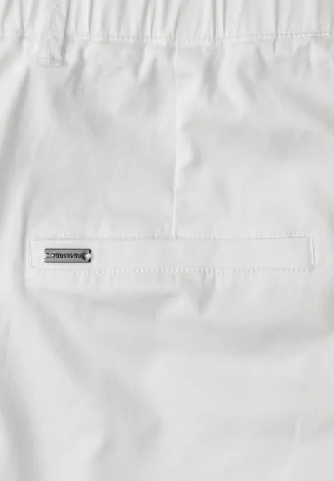 Wit kledingstuk met achterzak en klein metalen label aan de achterkant.