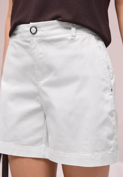 Een witte damesshort van katoen tot op de knie, met riemlussen en steekzakken.