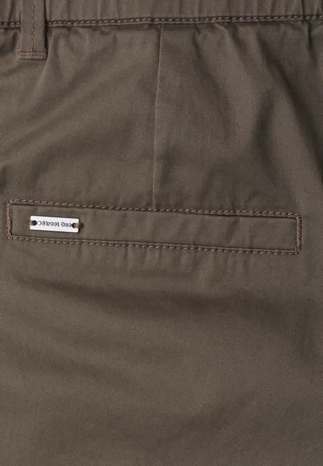 Braune Hose mit gestepptem Gesäßtascheneingriff und kleinem weißen Label 'TREKKING SHOP'.