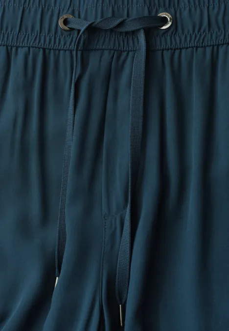 Nahaufnahme einer dunkelgrünen Hose mit elastischem Bund und Tunnelzug.