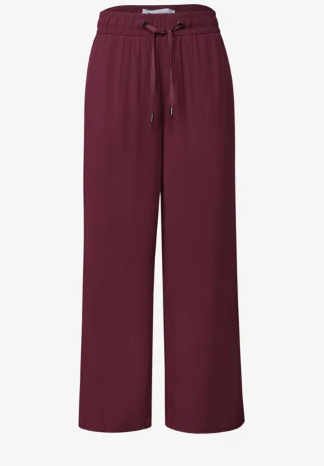Bordeauxrote, weite Stoffhose mit elastischem Bund und Kordelzug.