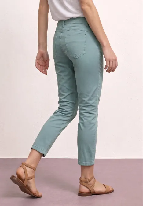 Persoon met muntgroene, enkelhoge broek en bruine sandalen.