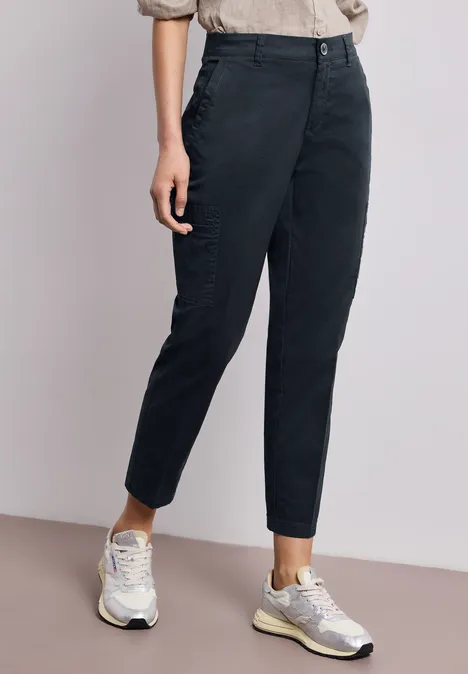 Strakke zwarte 7/8-broek gecombineerd met witte sneakers.