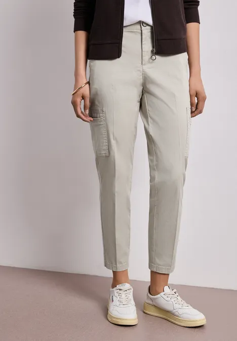 Beige cargobroek met zijzakken, gecombineerd met witte sneakers.