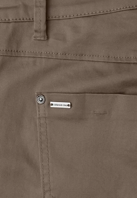 Close-up van een kaki broek met achterzak, riemlus en klein metalen label.