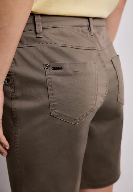 Achteraanzicht van een persoon met olijfgroene short en een licht shirt.