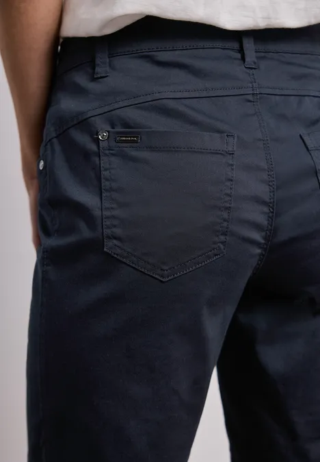 Close-up van een donkerblauwe broek van achteren met achterzakken.