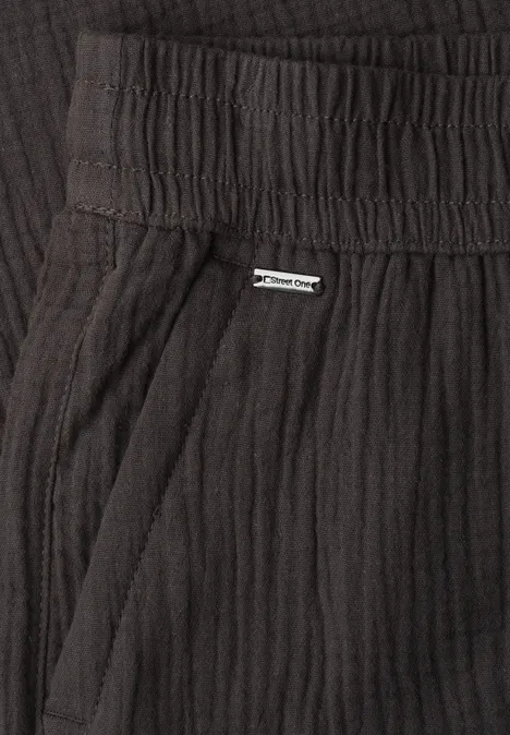 Schwarz gerippte Hose mit elastischem Bund, seitlicher Tasche und kleinem Metall-Label.