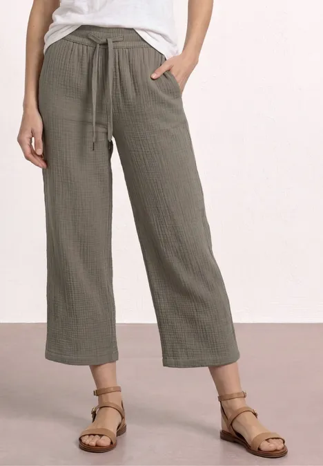 Lockere, khakifarbene Hose mit weitem Bein, Gummizug und seitlichen Eingrifftaschen.