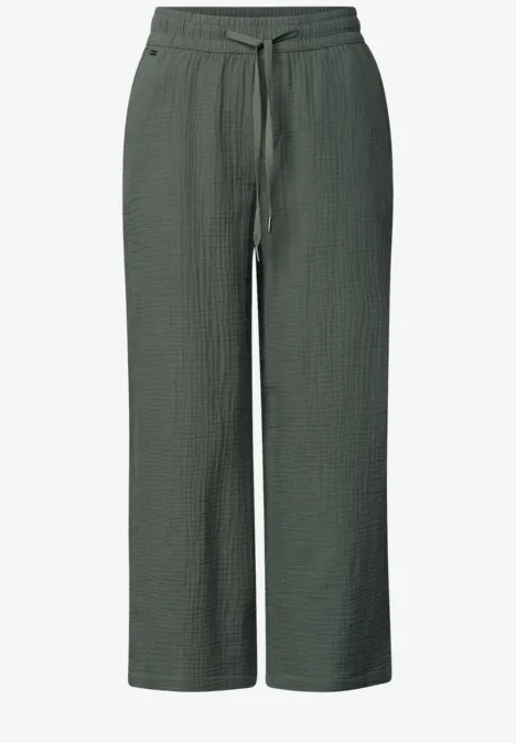 Dunkelgrüne, weit geschnittene Hose aus Strukturstoff mit elastischem Bund und Tunnelzug.