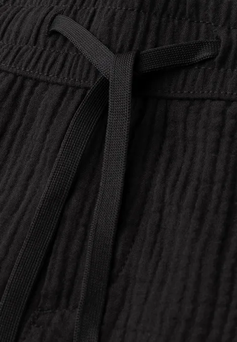 Nahaufnahme eines schwarzen, gekräuselten Stoffbunds mit Kordelzug.