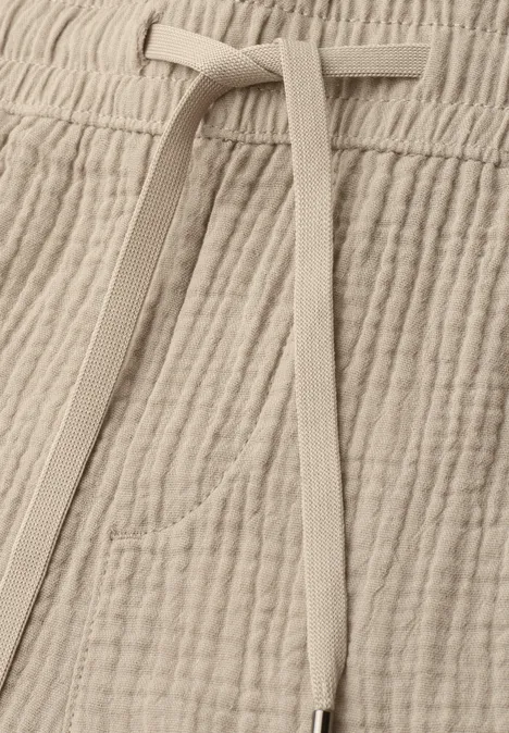 Pantalon beige en coton gaufré avec cordon de serrage et poche discrète.