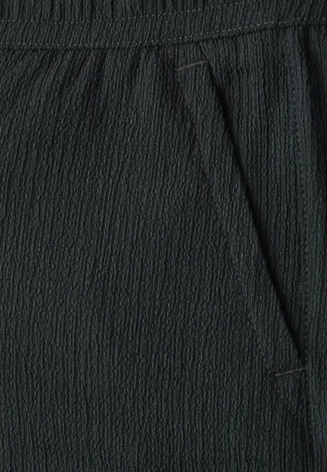 Schwarzer, strukturierter Stoff mit elastischem Bund und seitlicher Eingrifftasche.