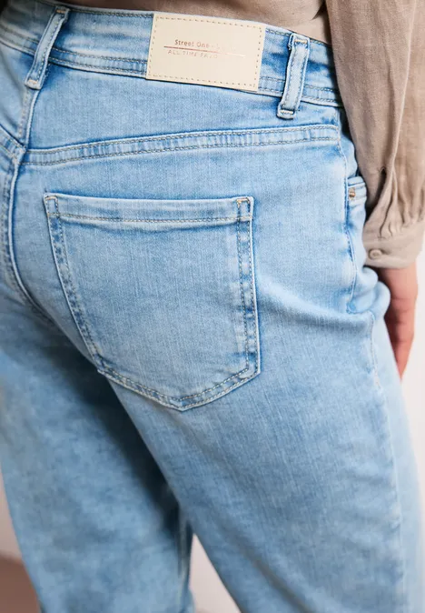 Rückansicht einer Person in hellblauen Jeans mit Gesäßtasche und Taillenlabel.