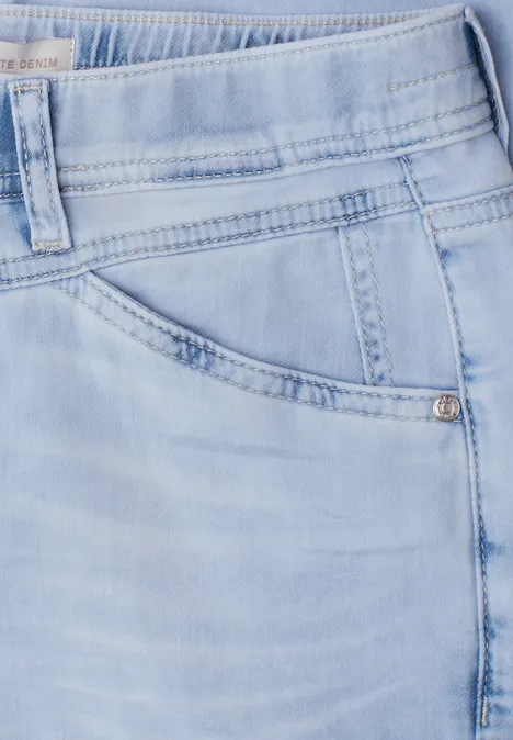 Nahaufnahme einer hellblauen Jeans, Fokus auf Tasche und Bund mit Nahtdetails.