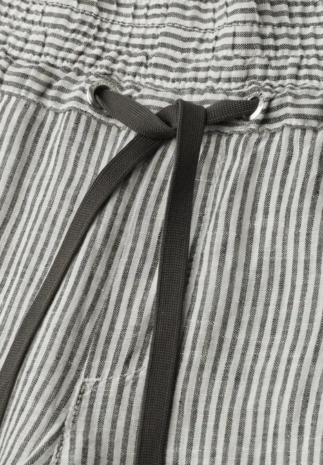 Gros plan d'un pantalon gris à rayures blanches avec cordon noir à la taille élastiquée