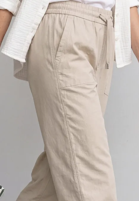 Helle beige Leinenhose mit Tunnelzugbund und Seitentaschen.