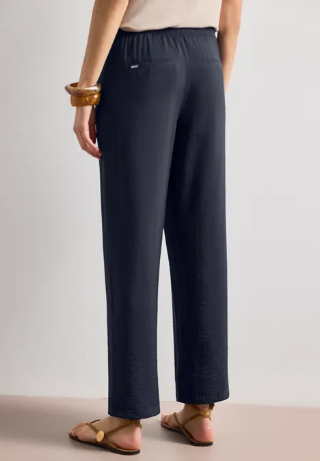 Pantalon droit en tissu sombre, coupe décontractée, matière douce.