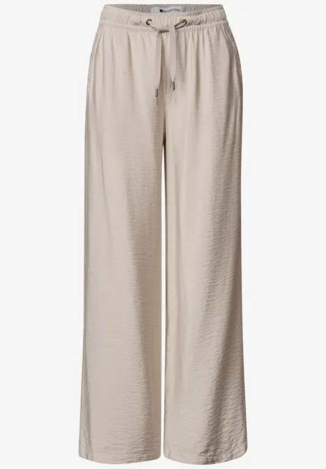 Pantalon ample beige en tissu léger et texturé, taille élastique avec cordon