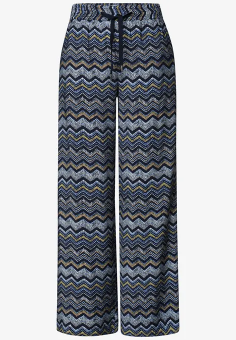 Wijde, losse broek met blauw-grijs zigzagpatroon, elastische tailleband en koordsluiting.