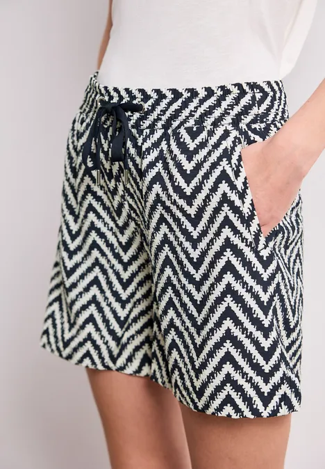 Frau trägt lässige Shorts mit navy-weißem Zickzack-Muster und Tunnelzug mit Kordel.